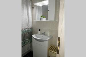 a white bathroom with a sink and a mirror at Cozy apartment in Ialysos +2 photos