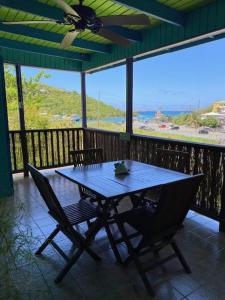 a table and chairs on a porch with a view at St John Inn in Contant