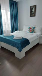 a bedroom with a bed with a blue and white bedspread at Casa MYM in Moisei