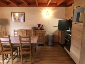 a kitchen with a table with chairs and a television at Chalet à CAUTERETS - 6 personnes in Cauterets