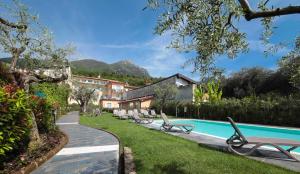um resort com piscina e espreguiçadeiras em Corte Benaco by Wonderful Italy em Toscolano Maderno