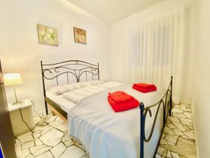 ポルト・ヴァルトラヴァーリアにあるAppartamento Buressoのベッドルーム1室(赤い枕のベッド2台付)