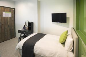 a hotel room with a bed and a television at T.O. Hotel - Taipei station in Taipei
