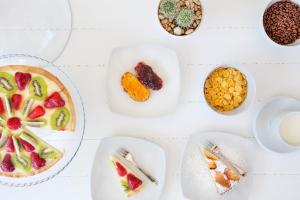 カステッルッツォにあるBaglio Fontanaの食べ物の皿が置かれた白いテーブル