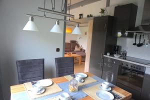 une cuisine et une salle à manger avec une table en bois et des chaises dans l'établissement Ferienhaus Hennesee, à Meschede