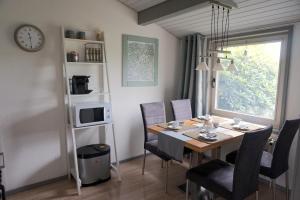 une salle à manger avec une table, des chaises et une horloge dans l'établissement Ferienhaus Hennesee, à Meschede