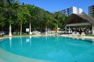 einen großen Pool mit Stühlen und einem Pavillon in der Unterkunft Ideal tu casa fuera de casa in Cancún