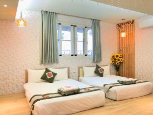 um quarto com 2 camas e uma janela em Splendid Flora B&B em Hengchun Old Town