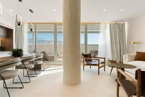 una sala de estar con una mesa, sillas y un sofá en ACRON suites & apartments, en Atenas