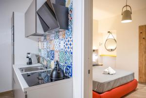 a small apartment with a sink and a bed at Incao Holiday Candeloro House in Cefalù