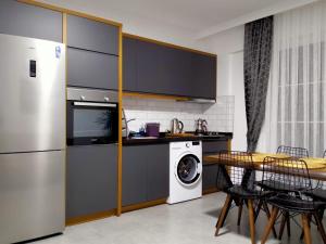 a kitchen with a refrigerator and a washing machine at Ada Apart Hotel Göcek in Göcek