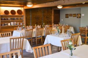 un comedor con mesas blancas y sillas de madera en Gasthaus Löwen, en Hemberg