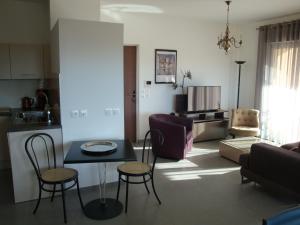una cucina e un soggiorno con tavolo e sedie di LE CARRE MONTFORT a Vaison-la-Romaine