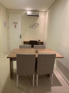 uma mesa de madeira e cadeiras num quarto em Apto Top Centrum Holambra/excelente localização em Holambra