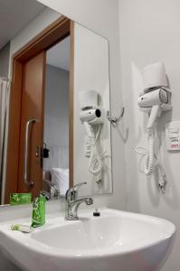um lavatório de casa de banho com 2 secadores de cabelo e um espelho em GRAAL INN ITATIAIA em Itatiaia