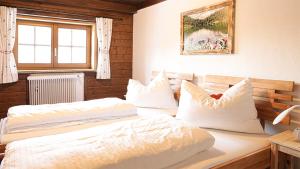 1 dormitorio con 2 camas y ventana en Landhaus Sommerbichl, en Embach