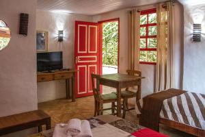 a room with a red door and a table and a desk at Espaço João Mineiro in Tiradentes