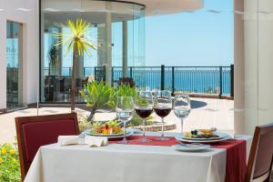 a table with wine glasses and food on a balcony at Cerro Mar Atlantico & Cerro Mar Garden in Albufeira