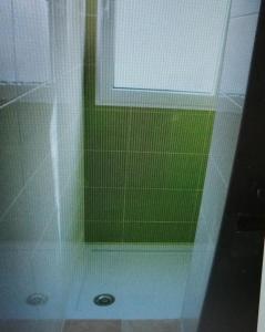a shower with a window and a green wall at Estudio Apartamento cerca de la playa in Playa Pobla de Farnals
