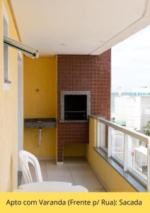 a room with a balcony with a tv and a fireplace at Residencial Dona Naime in Bombinhas