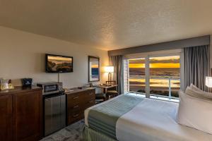 a hotel room with a bed and a view of the ocean at Driftwood Shores Resort in Florence
