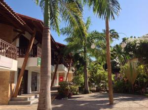 a row of palm trees in front of a building at Apartamentos La Piazzetta Duplex in Pipa
