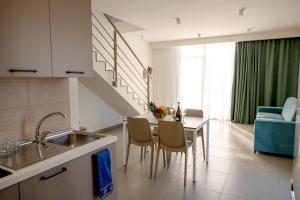 a kitchen with a sink and a table with chairs at Residence Salinelle Beach Villa Lipari 1 in Lascari