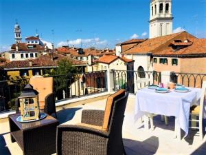 un patio con tavolo e sedie sul balcone. di VENICE HOLIDAY TERRACE a Venezia