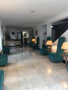 eine große Lobby mit blauen Stühlen und einem Klavier in der Unterkunft Hotel Castelo de Vide in Castelo de Vide