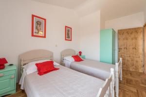 two beds in a room with two red pillows at Beautiful Mediterranean Villa Casa del Sol in Privlaka