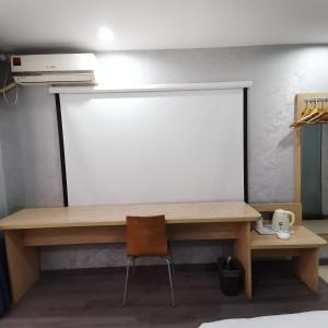 escritorio de madera con silla y pizarra en 7Days Inn Changsha Houjiatang Yali High School, en Changsha