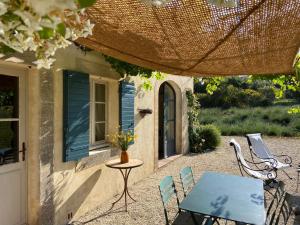 a patio with a table and chairs in front of a house at Le Clos d'Estellan - Piscine chauffée in Bonnieux