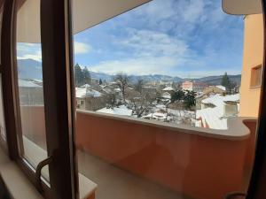 ein Fenster mit Blick auf eine verschneite Stadt in der Unterkunft Gelov Hotel in Berkowiza