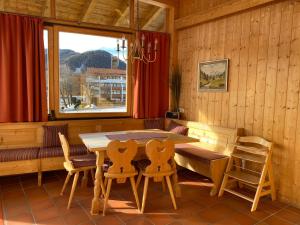 ein Esszimmer mit einem Tisch, Stühlen und einem Fenster in der Unterkunft Ferienwohnung Magdalena - ruhig, zentral, schöne Sonnenterrasse in Schliersee