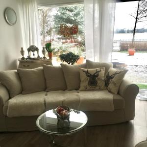 a living room with a couch and a glass table at Mazurska Villa Deluxe w Pasymiu z prywatnym pomostem na jezioro Kalwa i łodzią na wyłączność Najwyższe Premium w Osada Zamkowa in Pasym