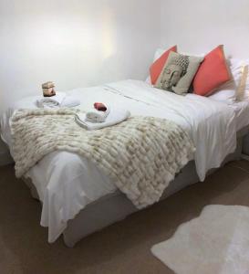 a bedroom with a bed with white blankets and pillows at Charming Cottage & Garden - central Brighton! in Brighton & Hove