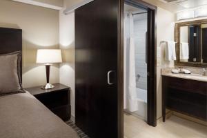 bagno con letto, doccia e lavandino di Aspen Select a Rochester