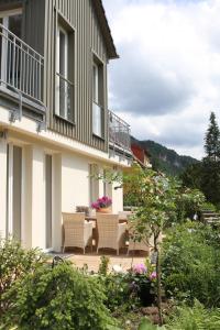 eine Terrasse mit Stühlen und einem Tisch vor einem Gebäude in der Unterkunft Haus Elbsinfonie in Bad Schandau