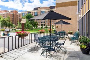 un patio con tavoli, sedie e un ombrellone di Aspen Select a Rochester