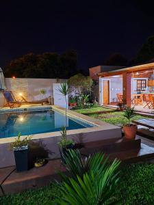 a swimming pool in the yard of a house at night at Apart portal de la selva in Puerto Iguazú