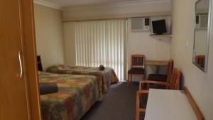 a hotel room with two beds and a table at Collie Motel in Collie