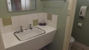 a bathroom with a sink and a mirror and a toilet at Collie Motel in Collie +20 photos