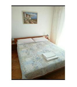 a bedroom with a bed with two plates on it at Apartmani Kelava in Podgora