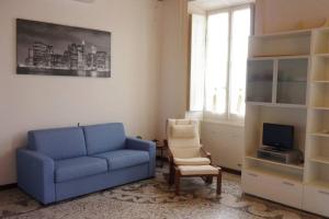 sala de estar con sofá azul y silla en Mare nostrum apartment en Lavagna