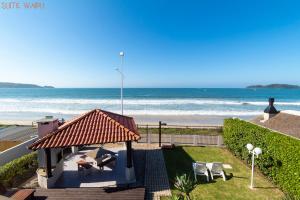 a view of the beach from the balcony of a house at Pousada Kia Ora Bombinhas in Bombinhas