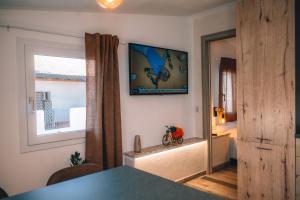 een woonkamer met een televisie aan de muur bij Appartamento Mare 2 in La Caletta