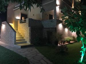 une maison avec un escalier dans une cour la nuit dans l'établissement Anna - Tsiara paradise studios, à Vourvourou