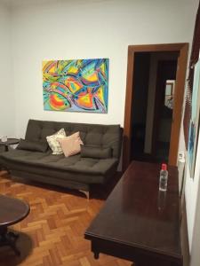 una sala de estar con sofá y una pintura en la pared en Conforto em Copacabana, en Río de Janeiro