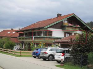 ein Haus mit davor geparkten Autos in der Unterkunft Hammerhaus-Apartment 3 in Siegsdorf