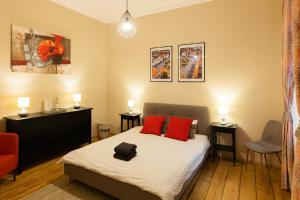 1 dormitorio con 1 cama con almohadas rojas en Chic Apartment in Historical City Center, en Timisoara